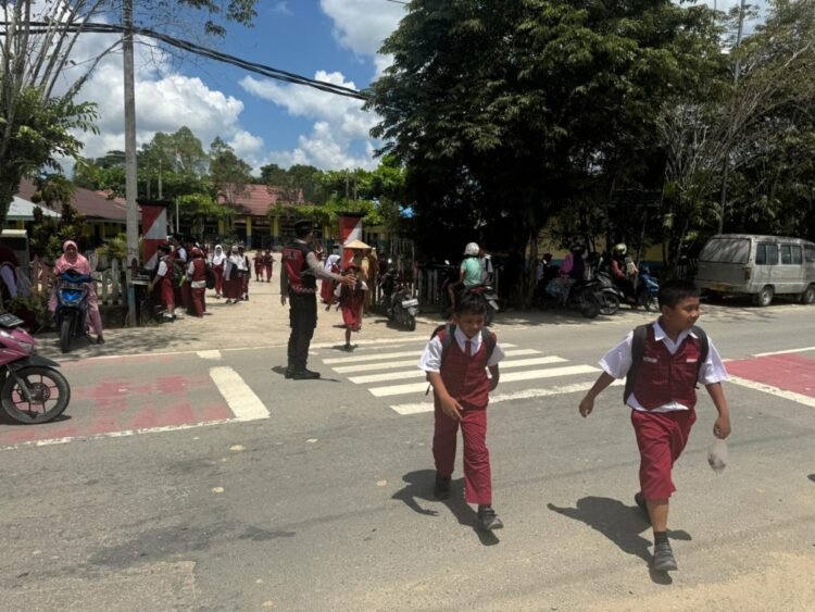 Beri Rasa Aman dan Nyaman, Personel Ditsamapta Polda Kaltara Bantu Anak Sekolah di SDN 020 Tanjung Selor Menyebrang Jalan